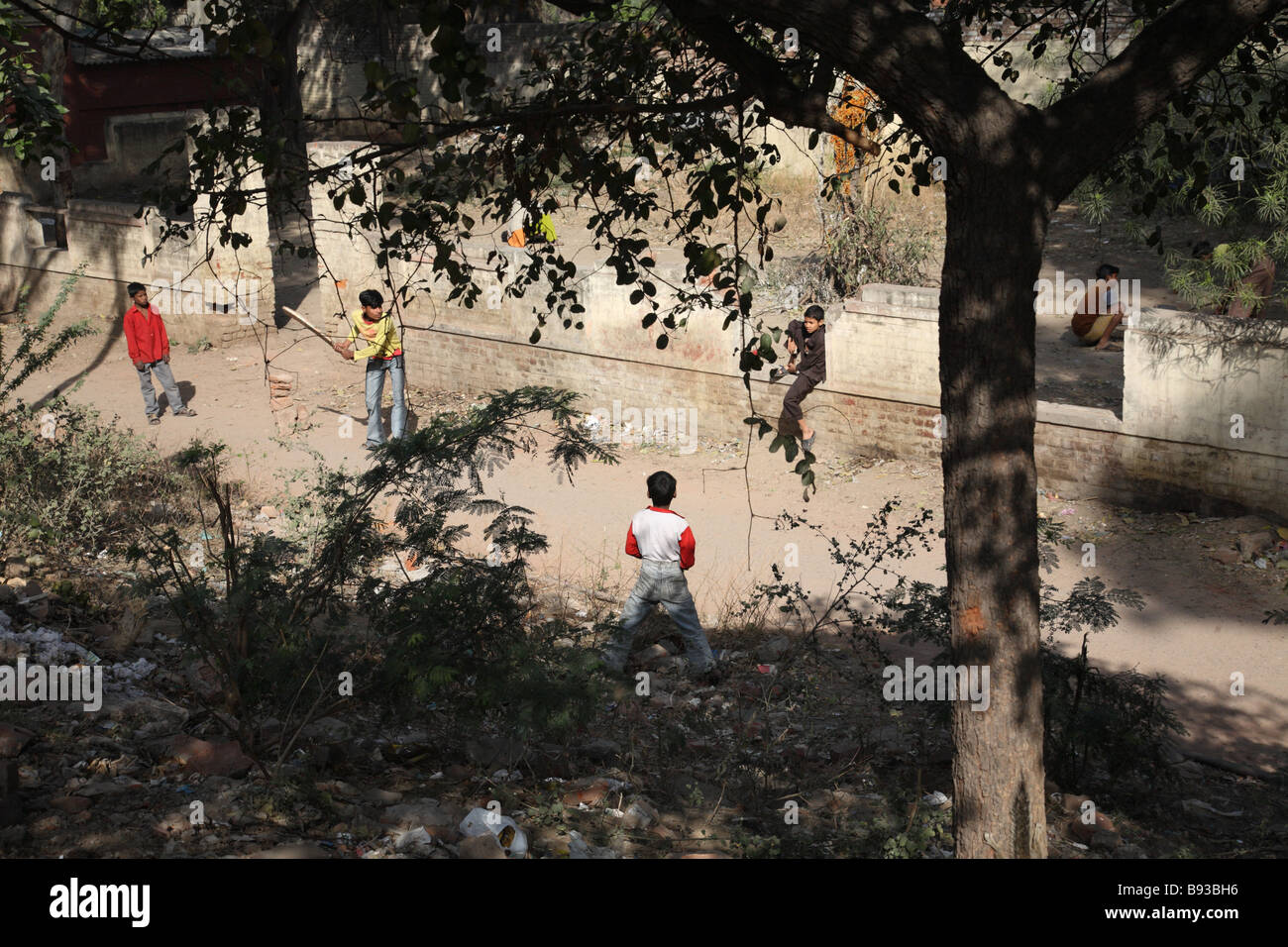 Young boys play a game of cricket by the side of the road near New Delhi Train Station, Delhi, India. Stock Photo