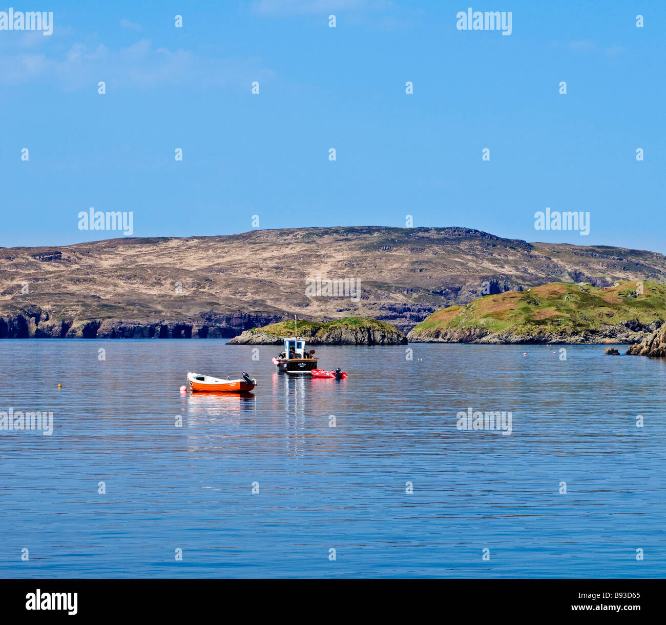 Boats moored at Tarbet with Handa island in distance, Tarbet, Sutherland, Scotland Stock Photo