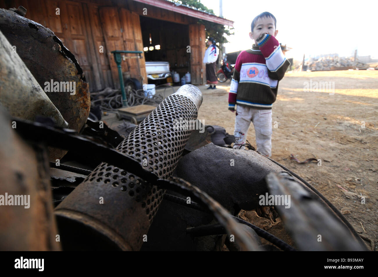A young boy in front of his home where his parents purchase bomb scrap from metal hunters in Phonsavan Laos Stock Photo