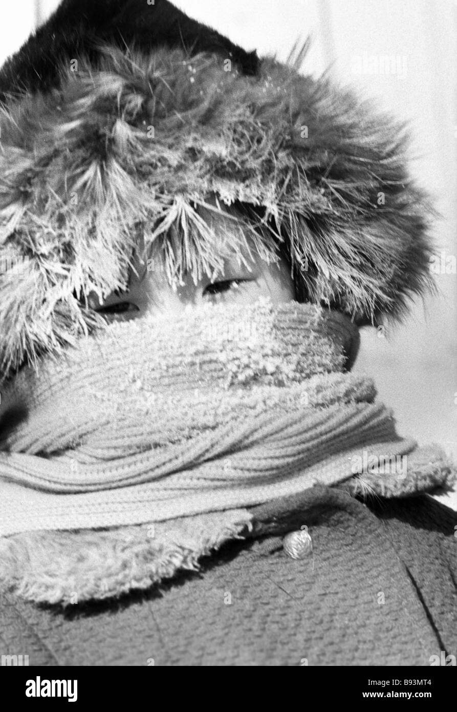 A Yakut reindeer breeders village child muffled up on a frosty day ...