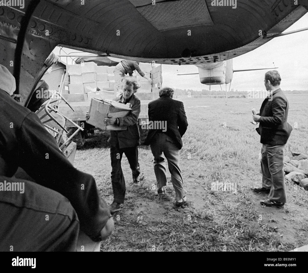 Geologist loading rock samples into the helicopter Stock Photo - Alamy