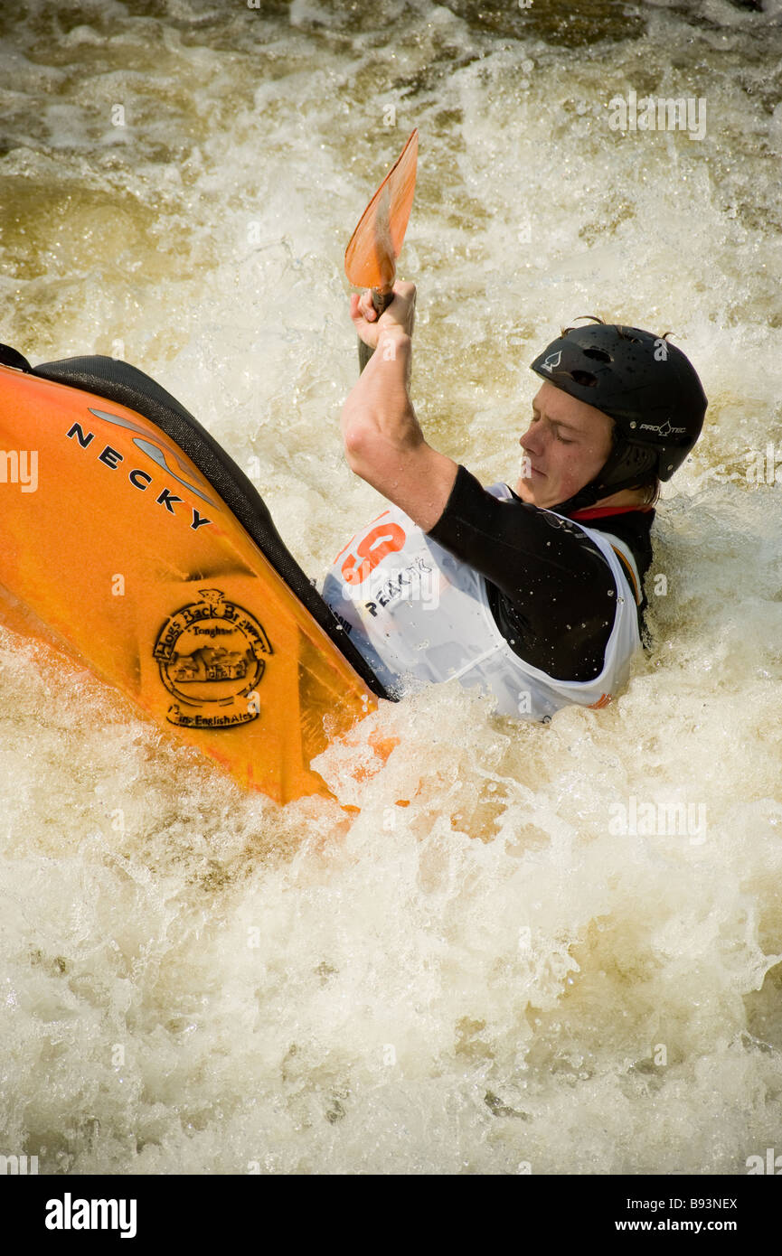 Kayaker with the stern of his kayak submerged whilst performing trick