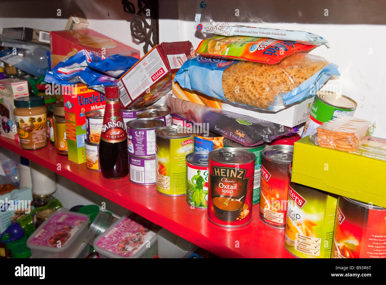 A cluttered untidy larder pantry housing lots of jars and tins etc