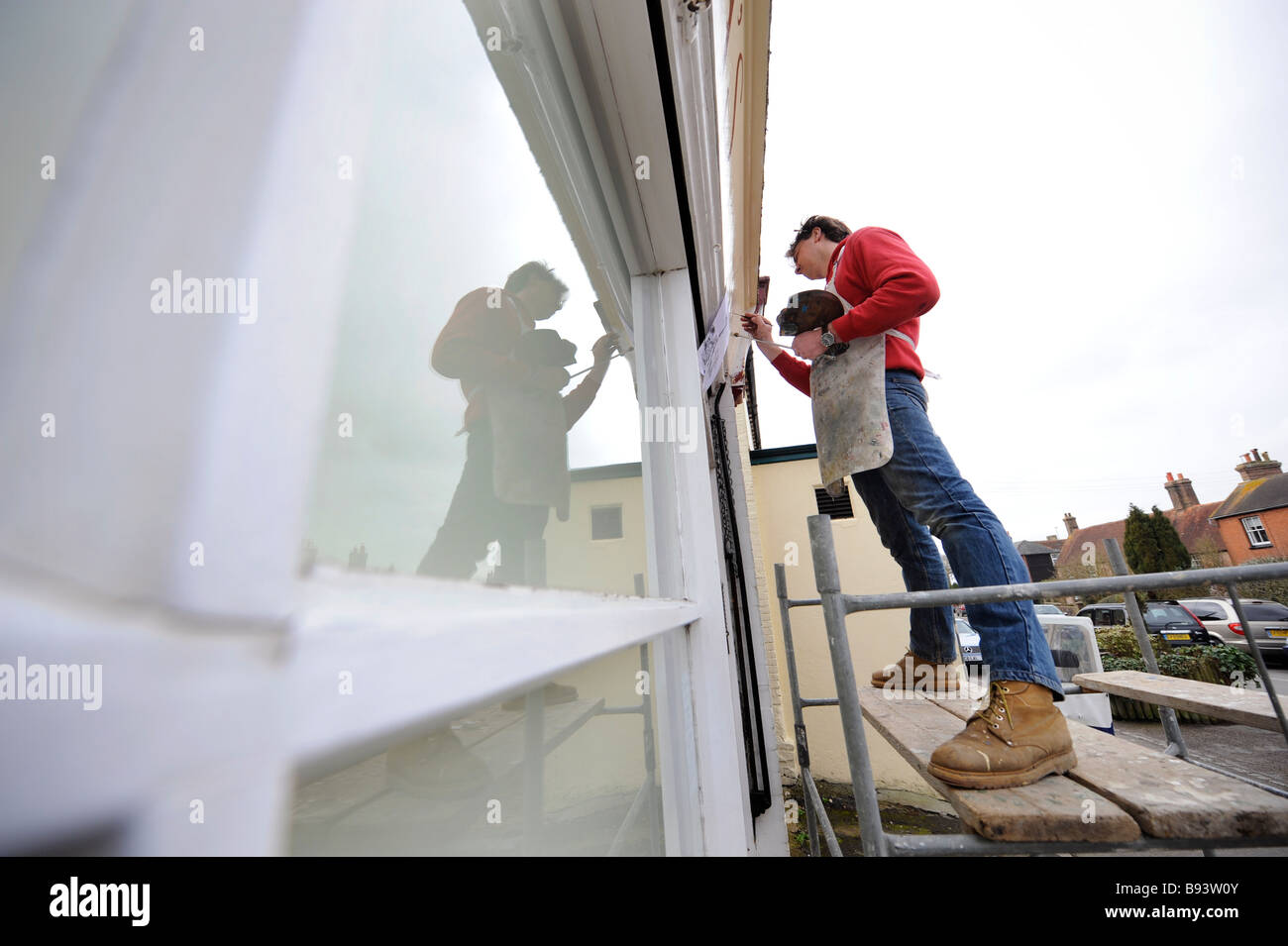 Sign painter Keith Pettit at work on a village shop front in East