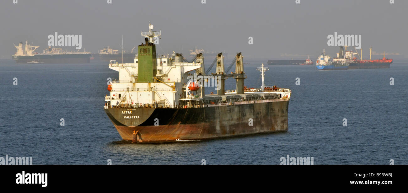 Shipping in heat haze including bulk carriers & oil tankers at sea anchorage off coast of Fujairah Gulf of Oman near Straits of Hormuz in Middle East Stock Photo
