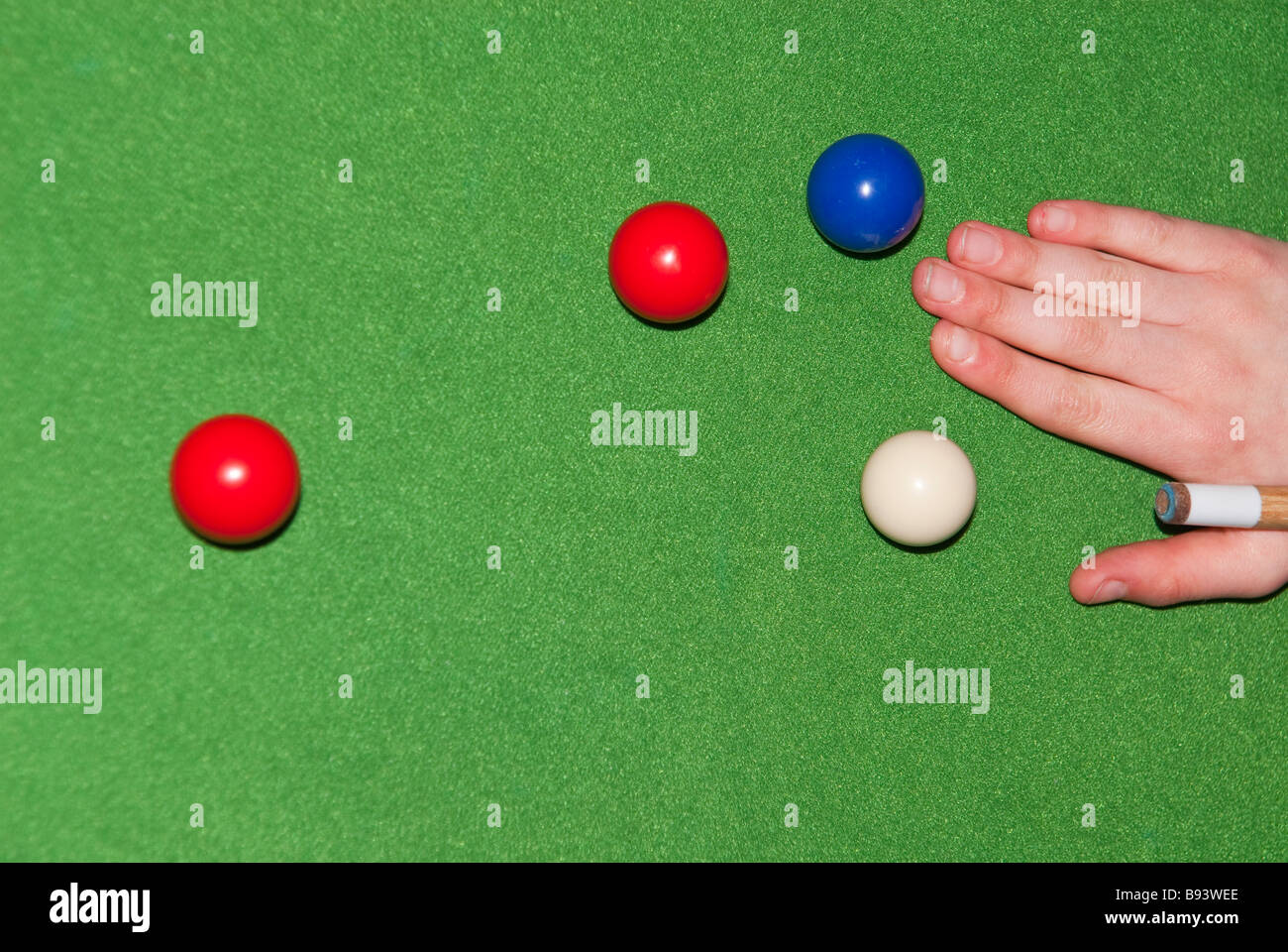 A close up of a persons hand resting a snooker cue about to take a shot ...