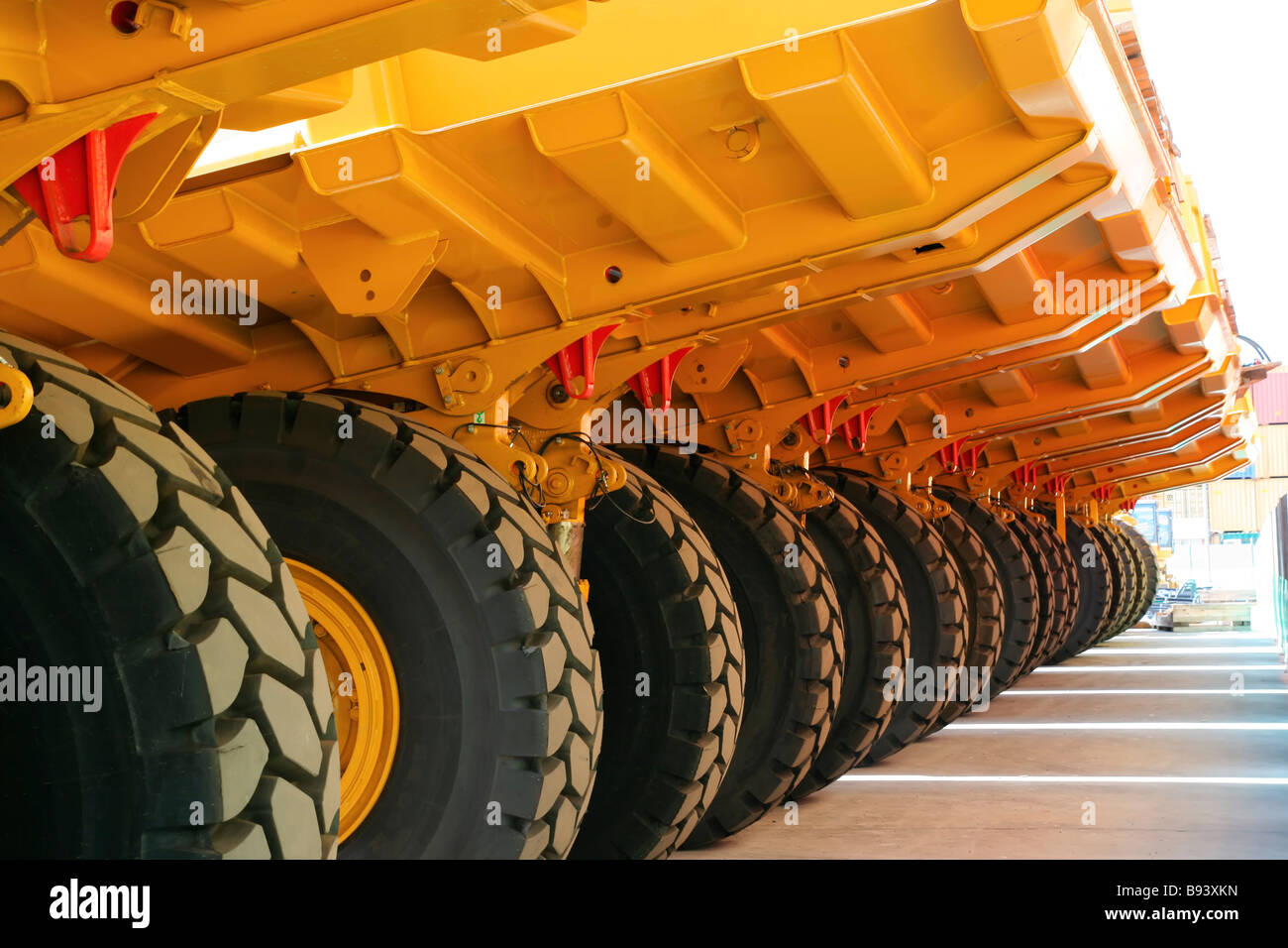 rear view or bottom of caterpillar articulated off highway dump truck neatly parked in repetitive pattern Stock Photo