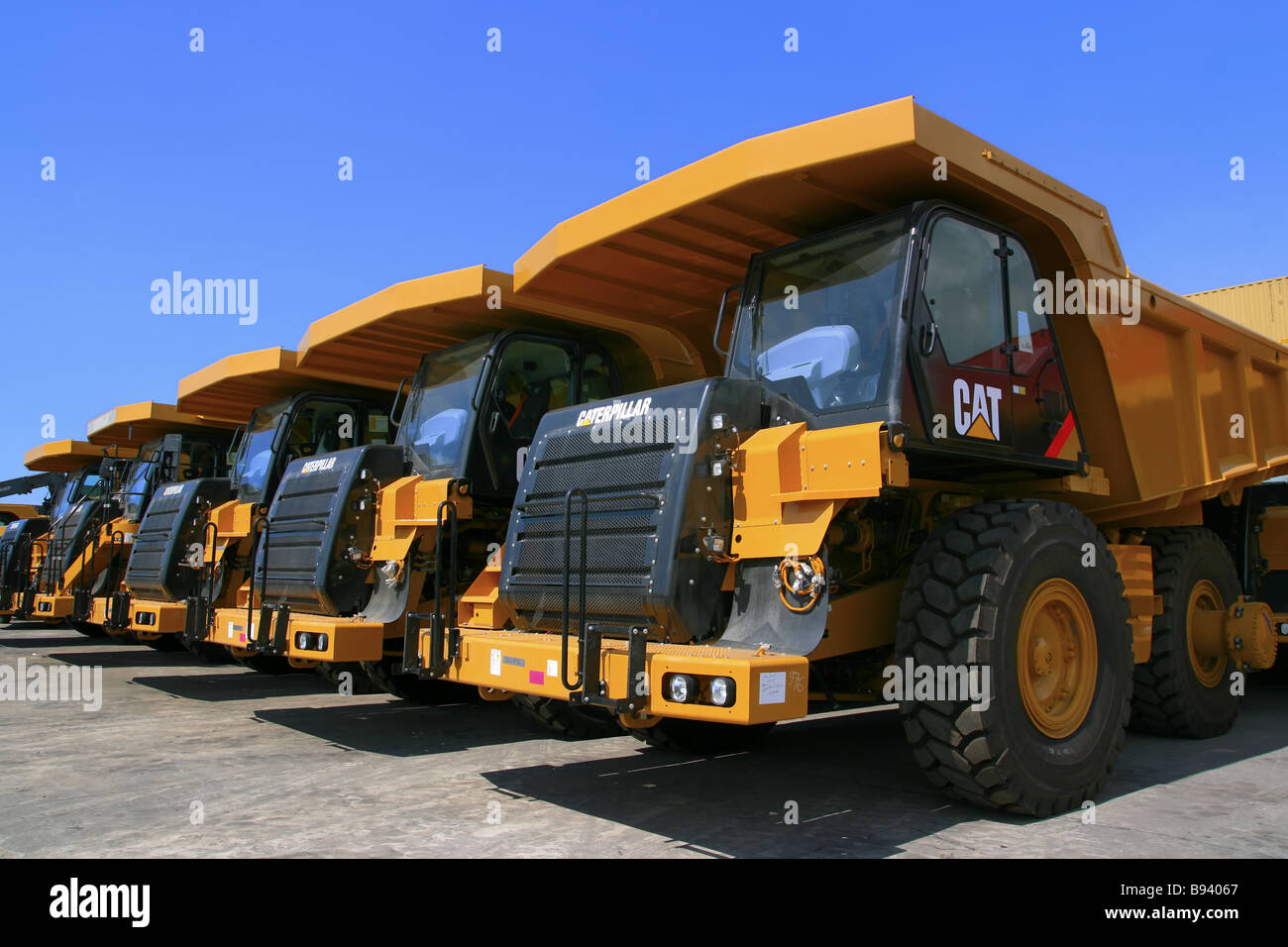 view of repetitive pattern of caterpillar articulated truck with blue background Stock Photo