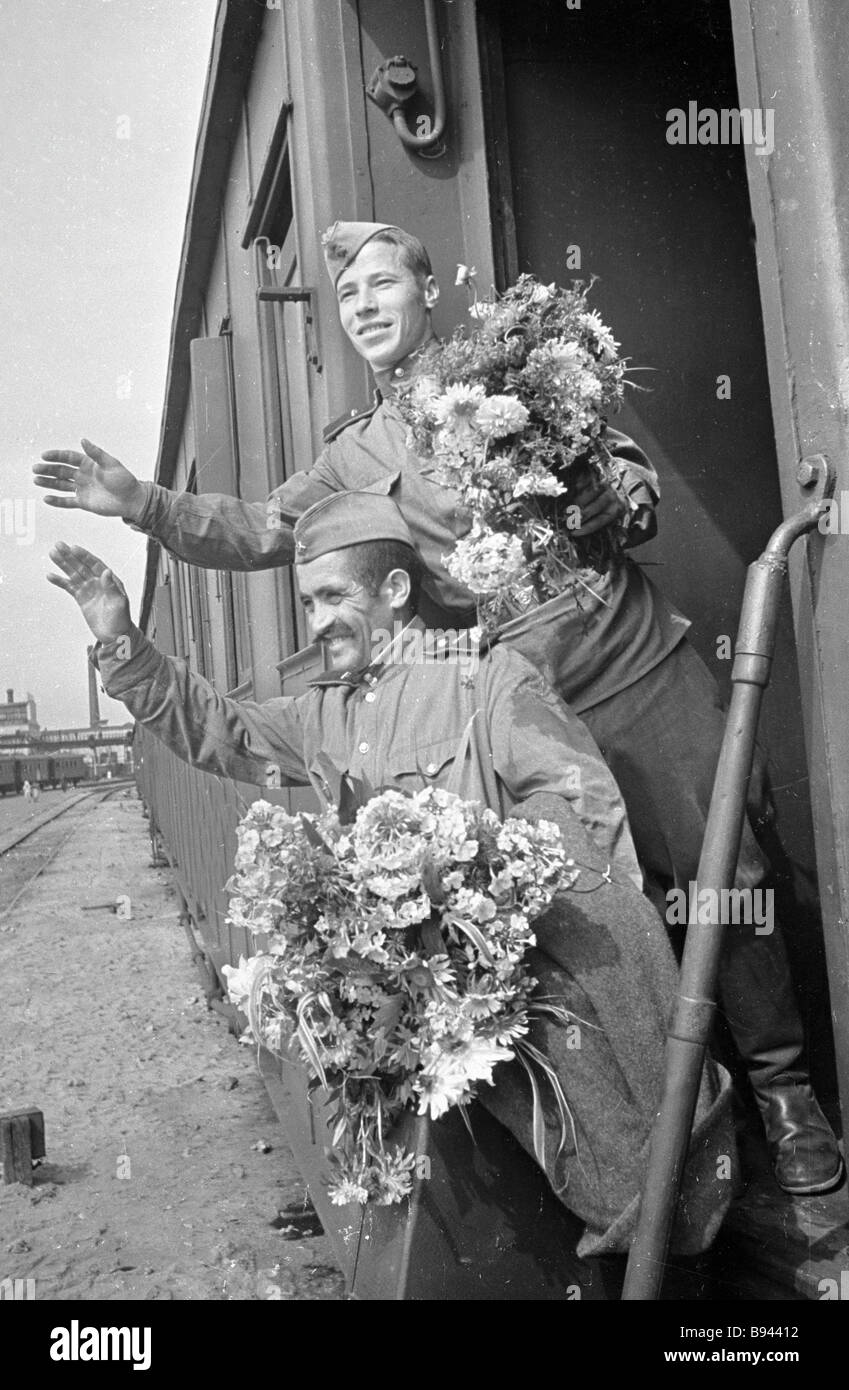 Soldiers transferred to the reserve with flowers waving goodbye from a