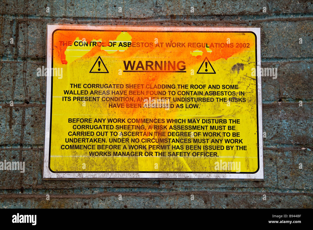 Asbestos warning sign in derelict factory Stock Photo