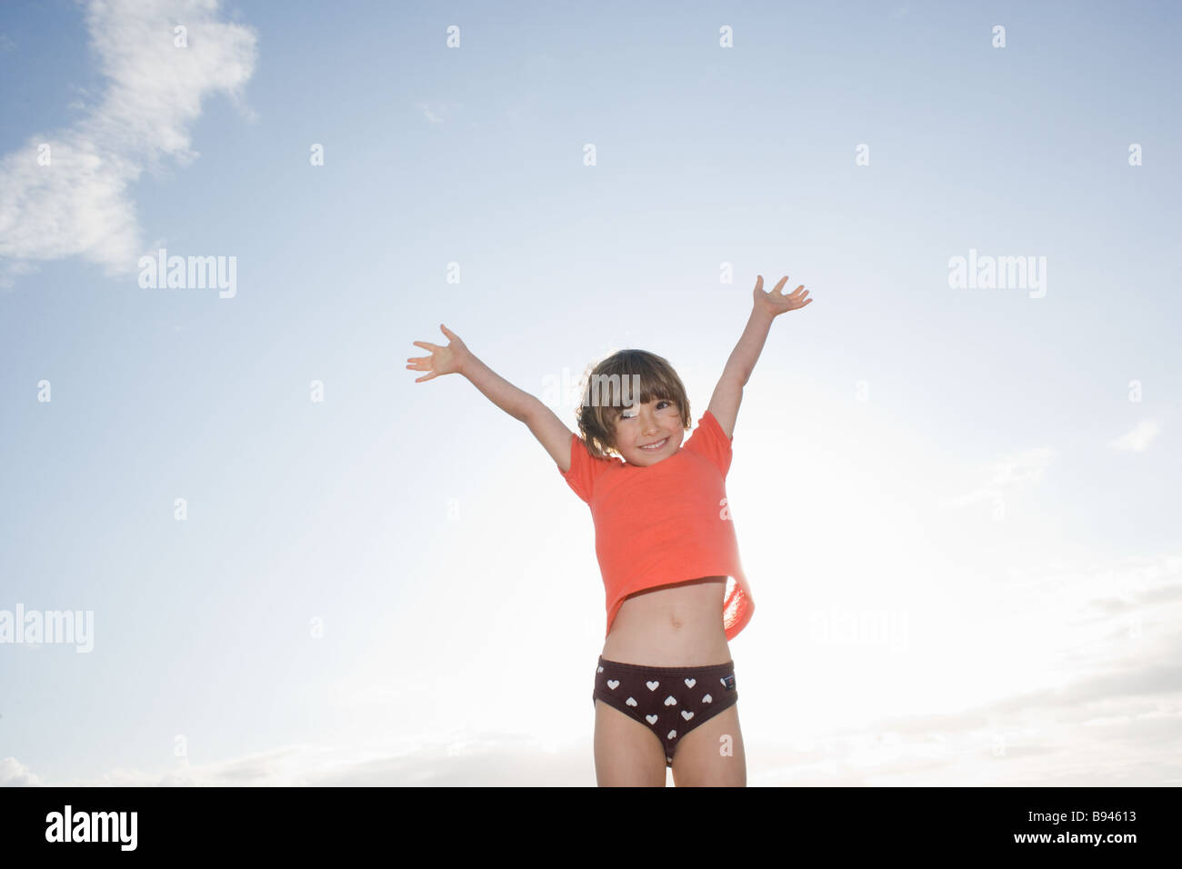 Girl throwing arms up towards blue sky Stock Photo Alamy
