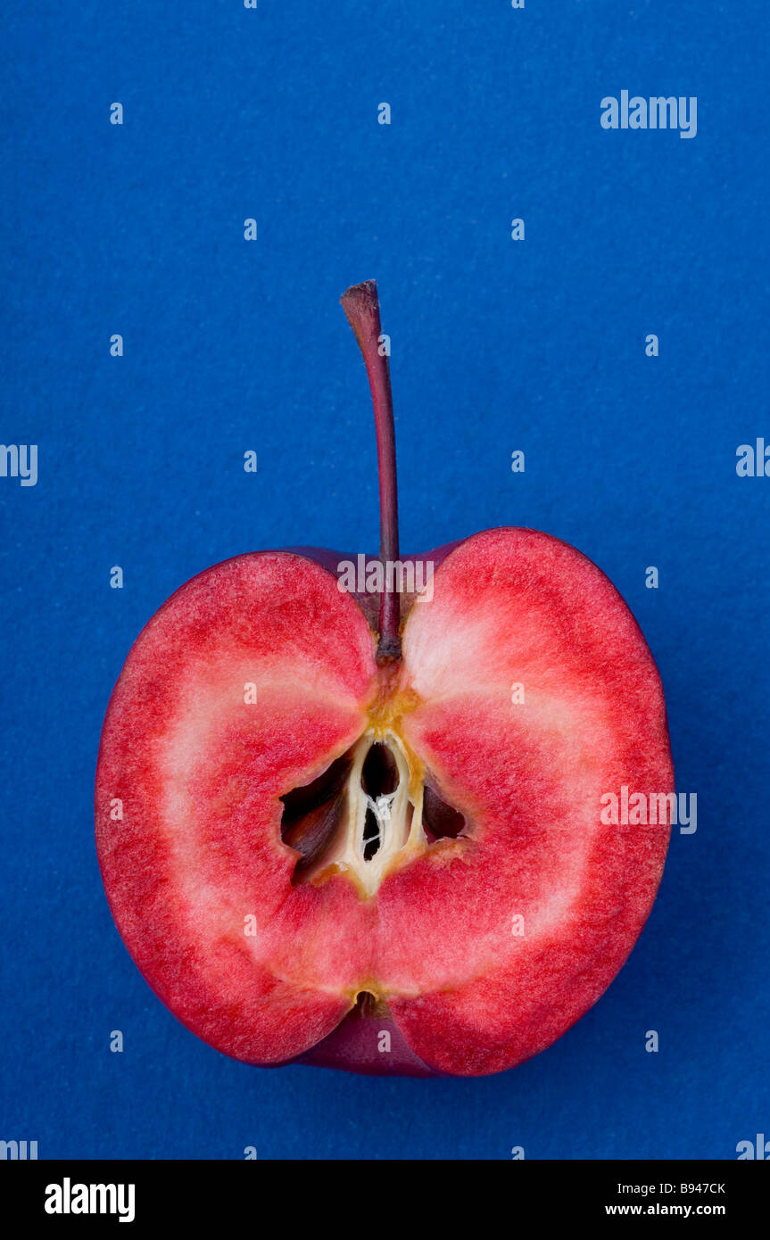 A crab apple cut in half to show the red interior of the fruit Stock Photo