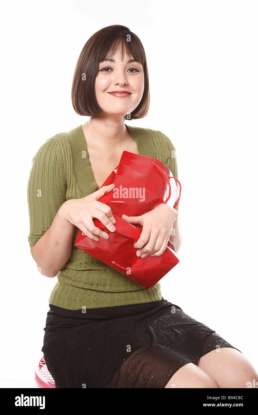 Woman holding red gift bag tightly Stock Photo
