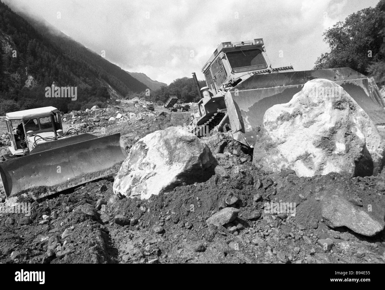 330 HP strong bulldozers removing mudslide boulders from road Stock Photo Alamy