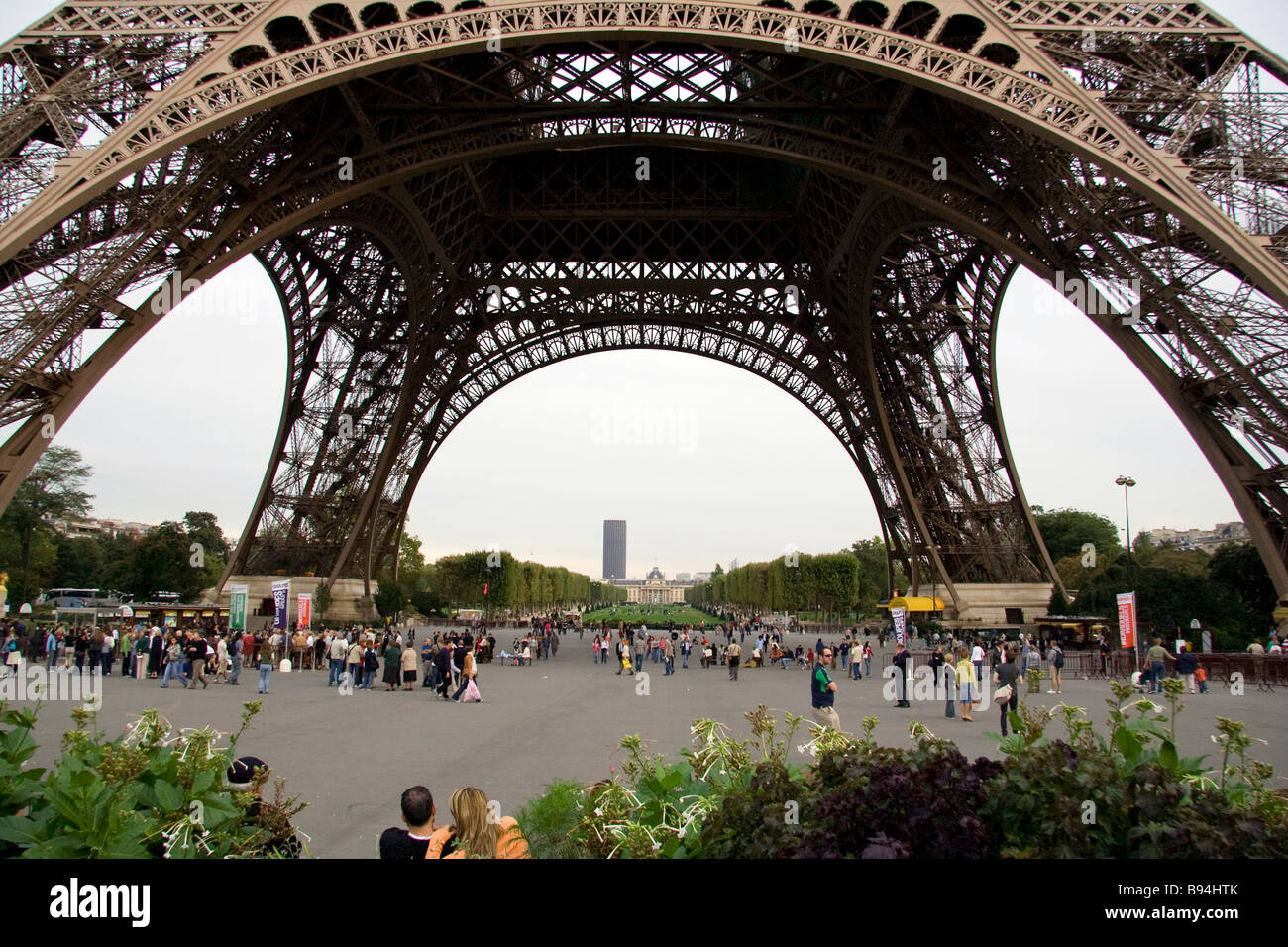 Eiffel Tower base with tourists and sightseers gathering and queuing to go up the structure. Stock Photo