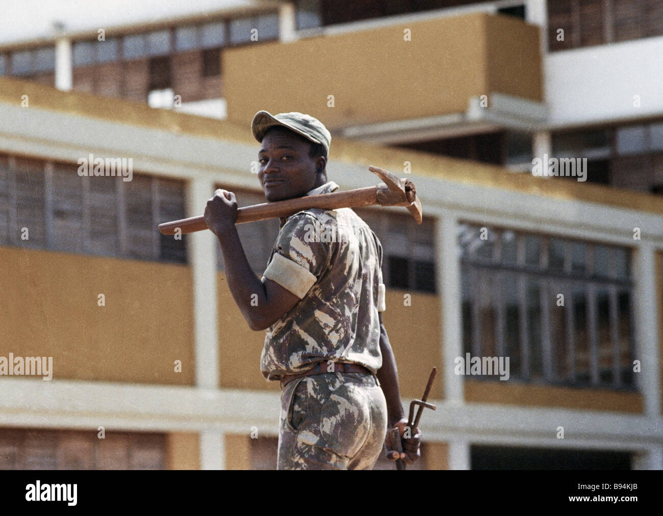 Worker carrying hammer pick on his shoulder the Republic of Mozambique Stock Photo