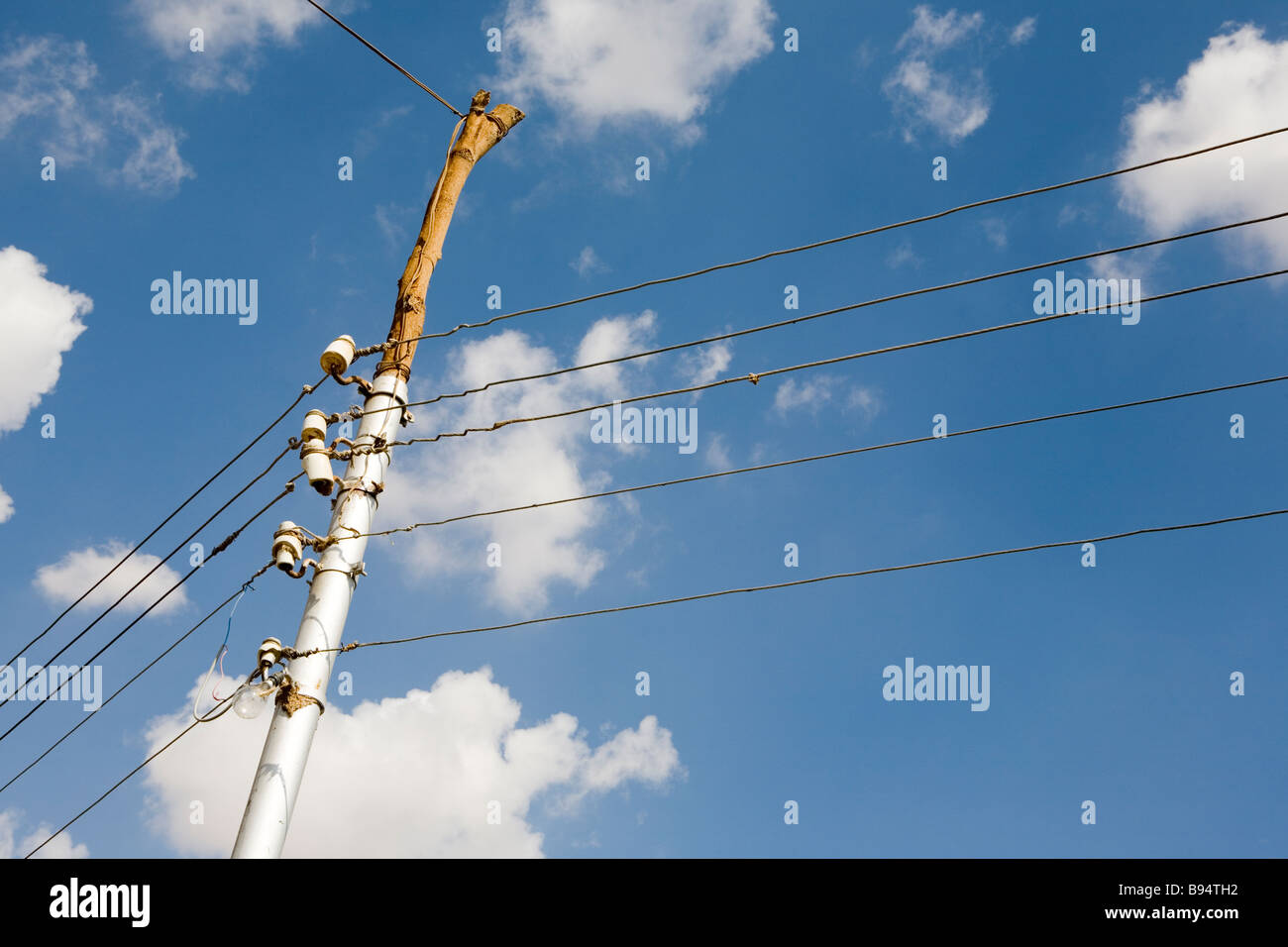 Communication wires on a wooden standing pole against blue and cloudy ...