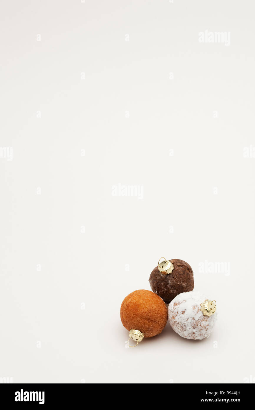 Three donut holes with Christmas ornament tops Stock Photo
