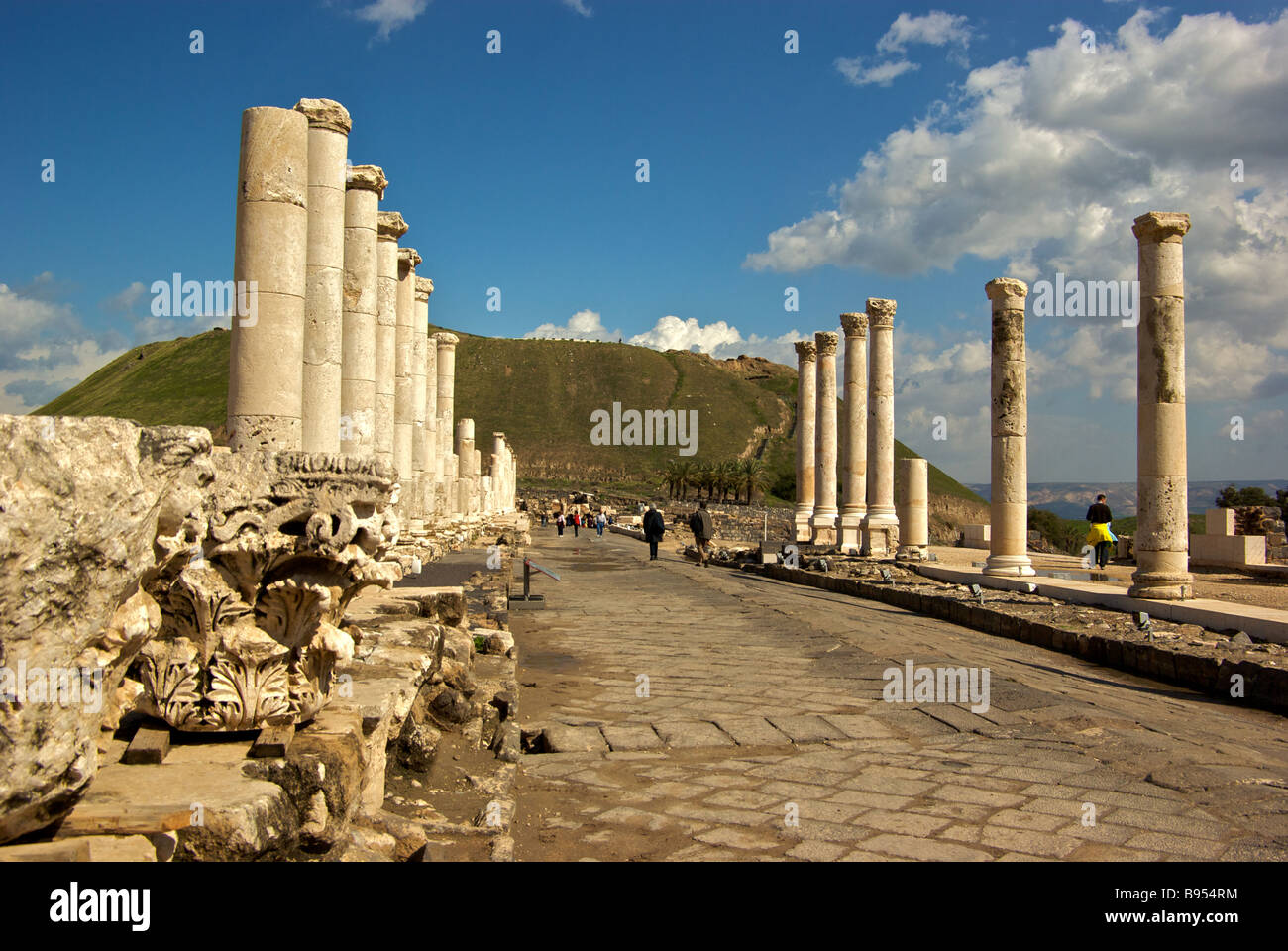 Marble colonnades line Palladius Street at ancient Roman Byzantine period city Scythopolis with great tell in background Stock Photo