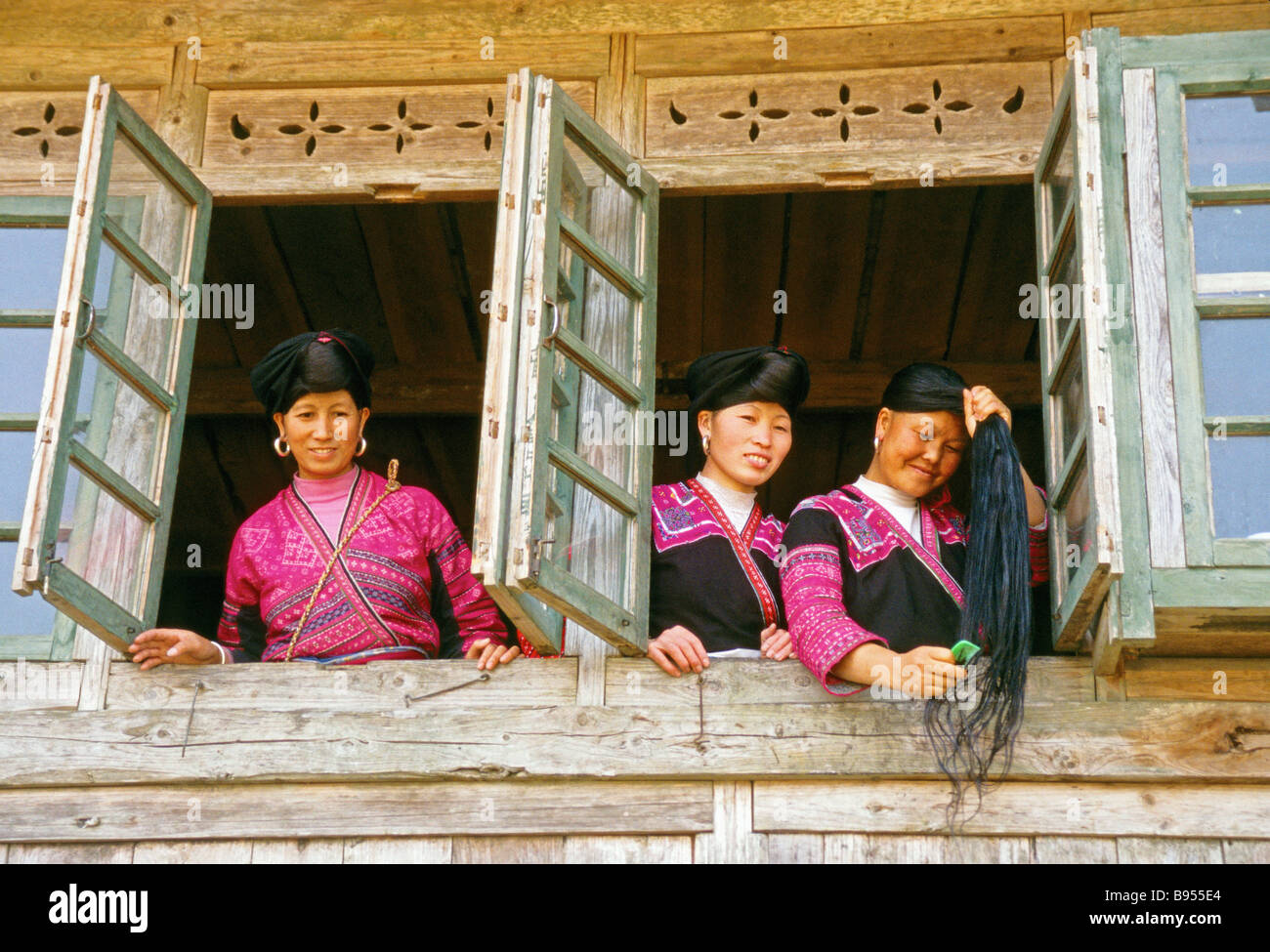 Red Yao nationality women in Longsheng County at Longji's Ping'an village with one combing hair Stock Photo