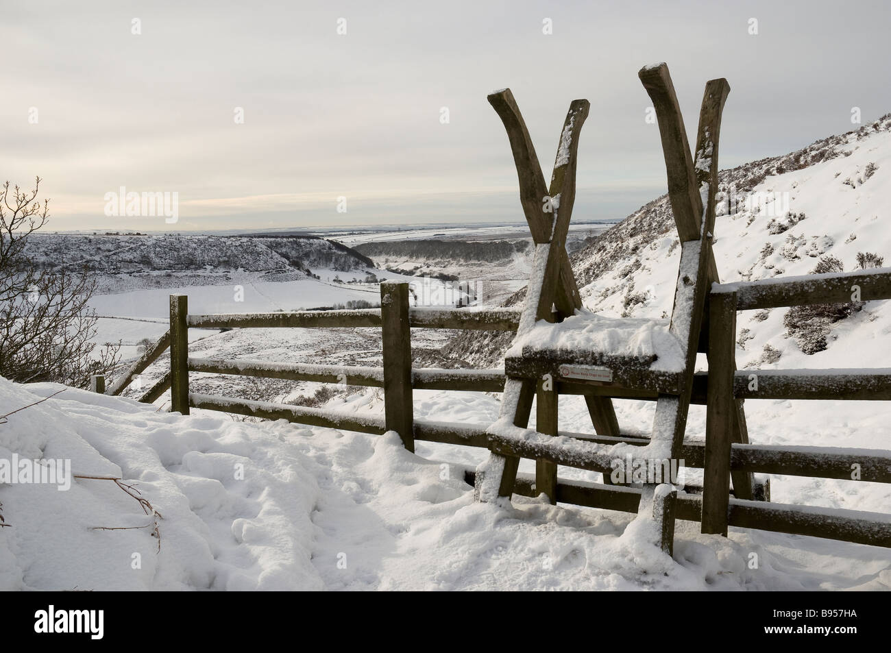 Wooden ladder stile over fence in winter snow Hole of Horcum North Yorkshire England UK United Kingdom GB Great Britain Stock Photo
