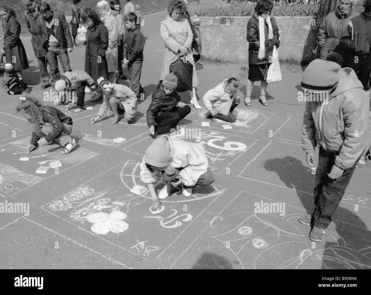 Children are drawing with crayons on asphalt at a children s drawing ...