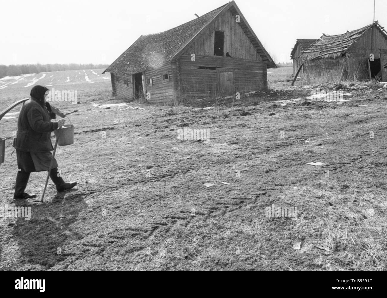 A village woman against the demolished village houses Stock Photo