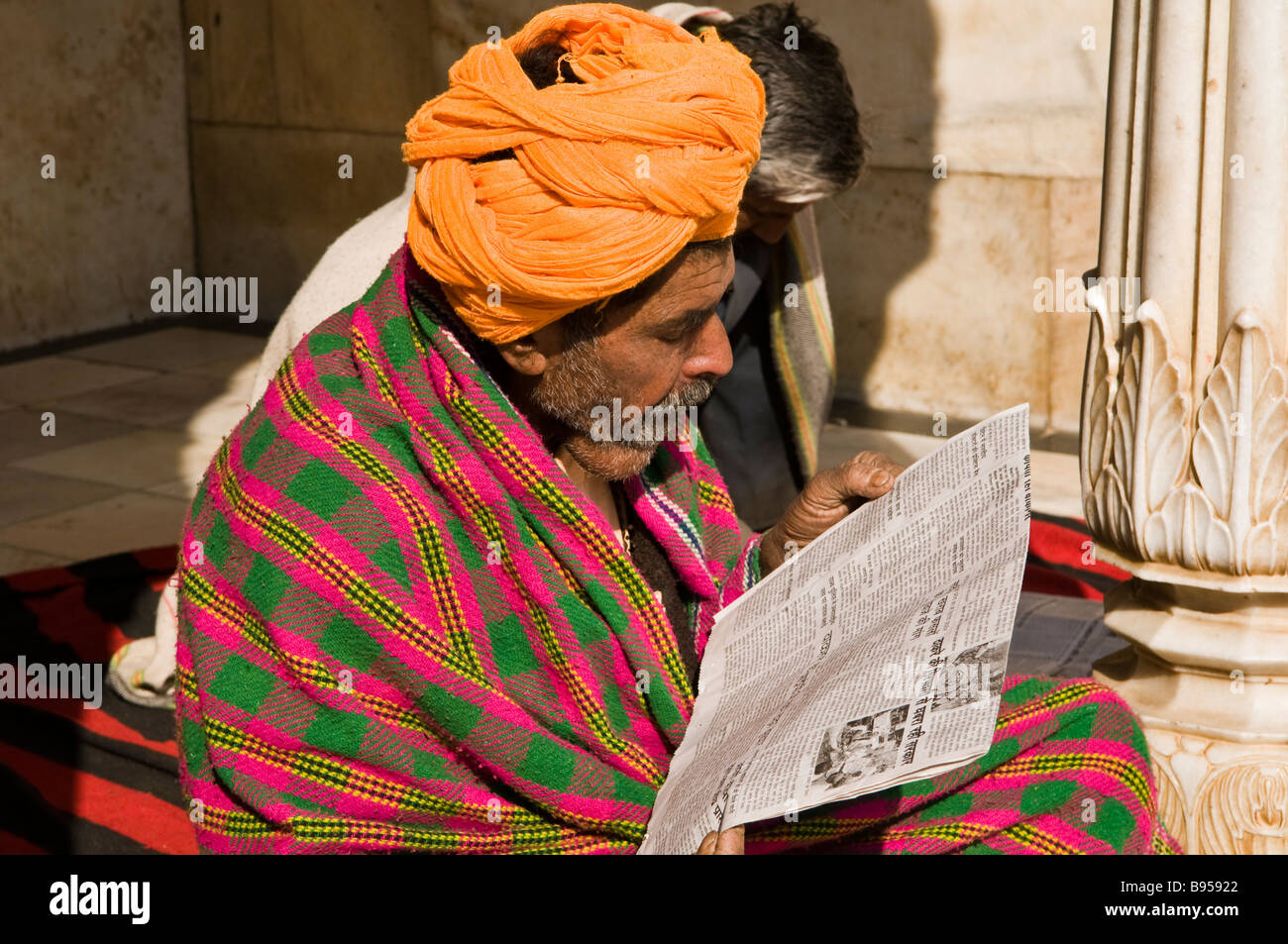 A man reads his newspaper inside the famous Rat temple of Karnimata located in Dishnoke ,south of the city of Bikaner, Rajasthan Stock Photo