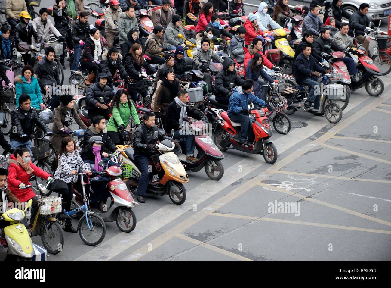 Crowd on bicycles and motor bikes crossing over in Shanghai Stock Photo