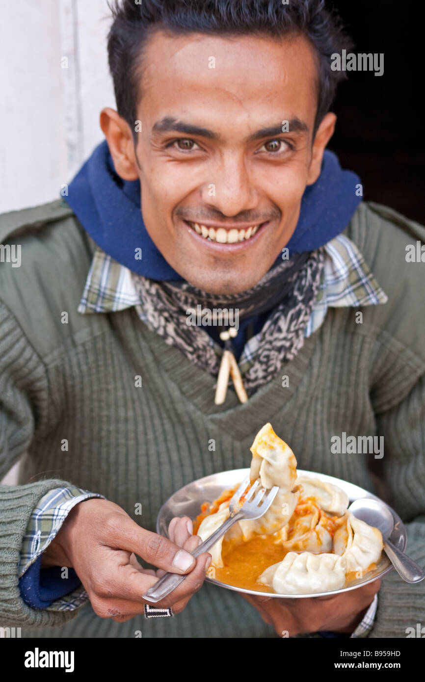 Nepali guy enjoying momo's in Kathmandu's Freak street, Nepal Stock Photo