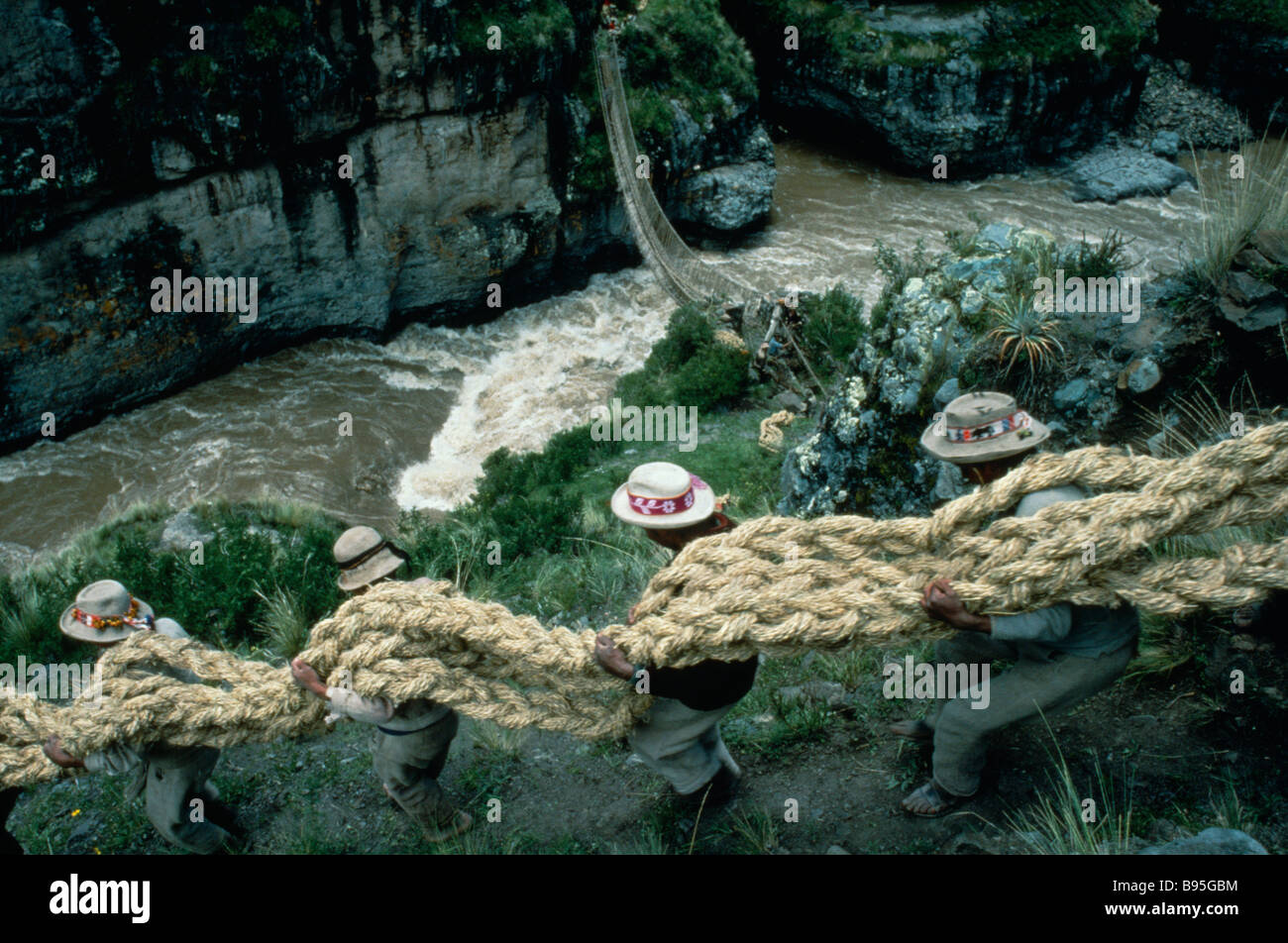 PERU Apurimac River Chumbivilcas Hills men carrying thick grass