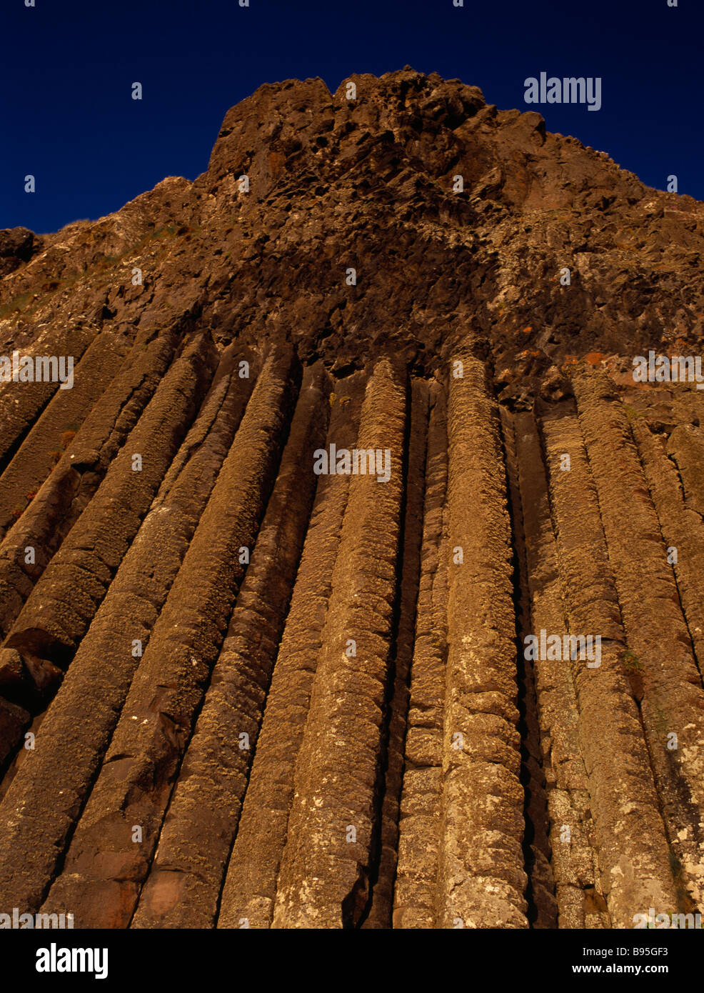 Northern Ireland, County Antrim, Giants Causeway.  Detail of section known as The Organ with rock pillars seen in golden light. Stock Photo