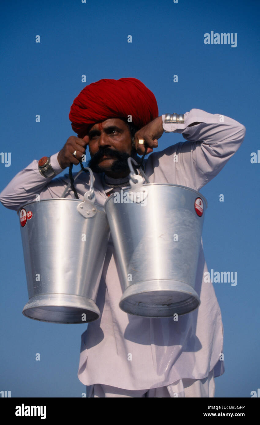 INDIA Rajasthan Bikaner Rajput man lifting buckets of water with his
