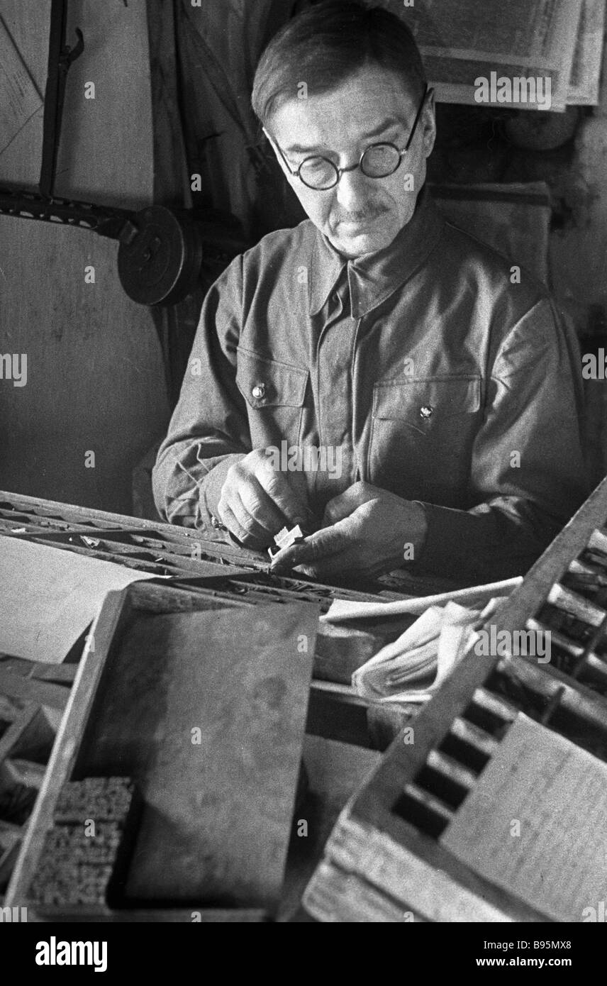 Printing house worker typesetting an army newspaper issue Stock Photo