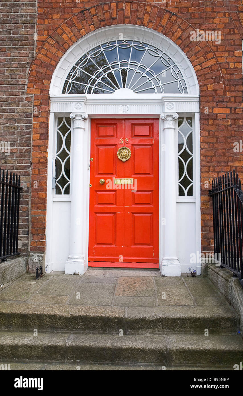 Ireland, Dublin. Georgian doorway near Merrion Square with red painted door and white surround with columns and glass insets. Stock Photo