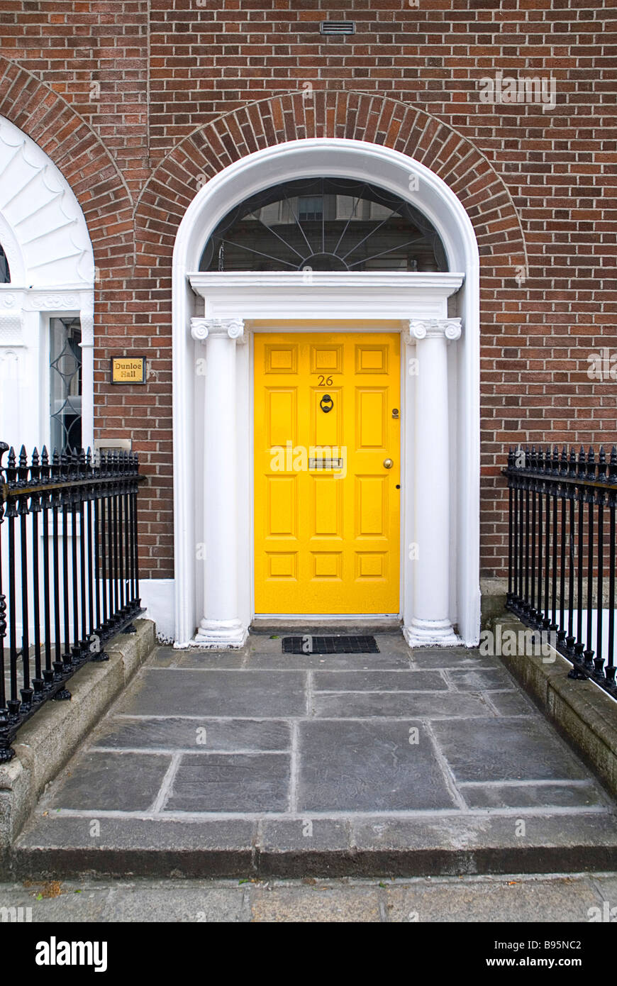 Ireland, Dublin. Yellow painted Georgian doorway near Merrion Square with white painted portico and side columns. Stock Photo