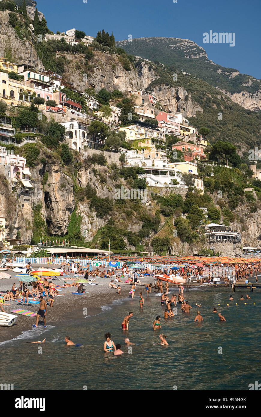 Italy, Campania, Salerno, Positano, busy Spiaggia Grande beach on the Amalfi Coast with buildings on steep hillside behind. Stock Photo
