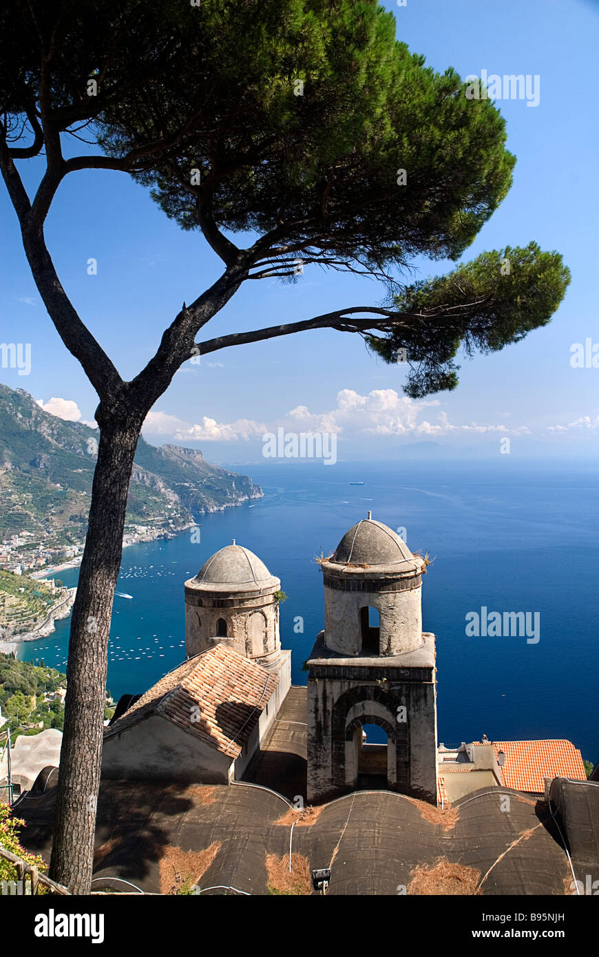 Italy, Campania, Salerno, Ravello, Church of Santissima Annunziata below Villa Rufolo with tree and view along coast beyond. Stock Photo