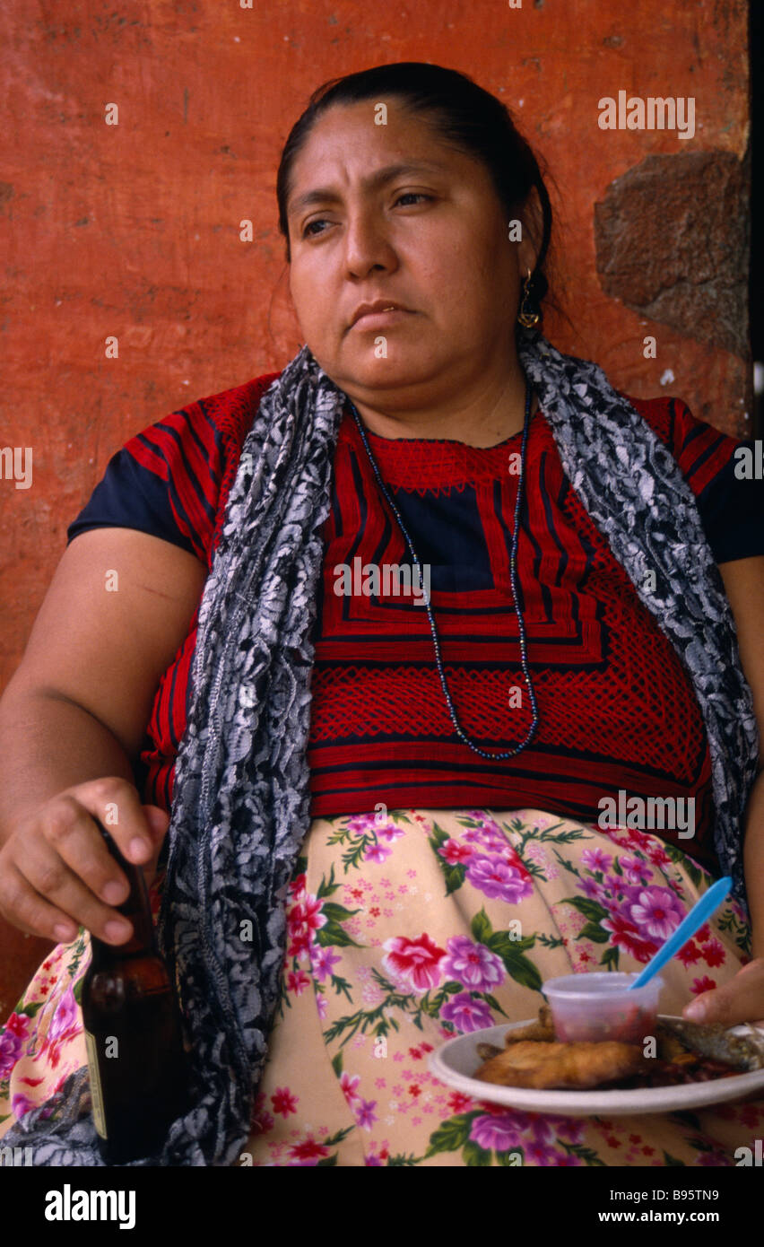 MEXICO Oaxaca Juchitan Matriarchal society. Portrait of seated women holding bottle and plate of food. Stock Photo