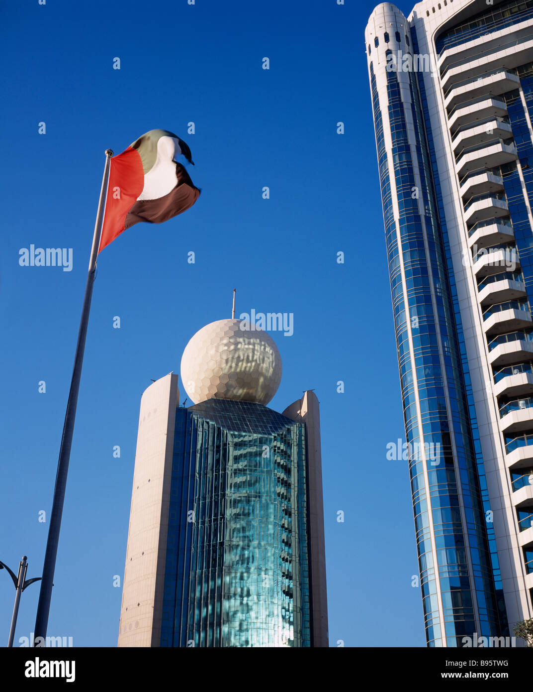 UAE Dubai Deira Etisalat Building on Dubai Creek with flag pole in foreground. Stock Photo