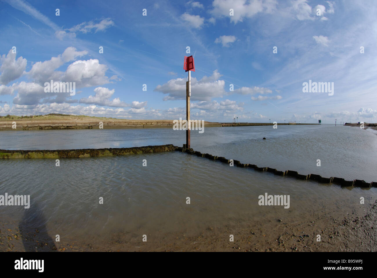 entrance channel to Rye Harbour, Sussex with red topped navigation post Stock Photo