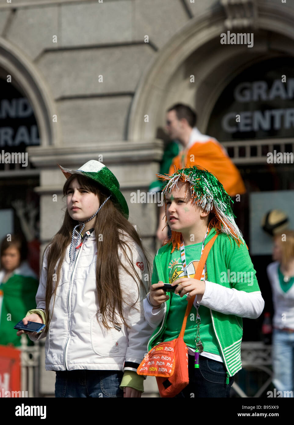 Two young girls watching the Dublin St Patrick s Day Parade on O Connell Street Stock Photo