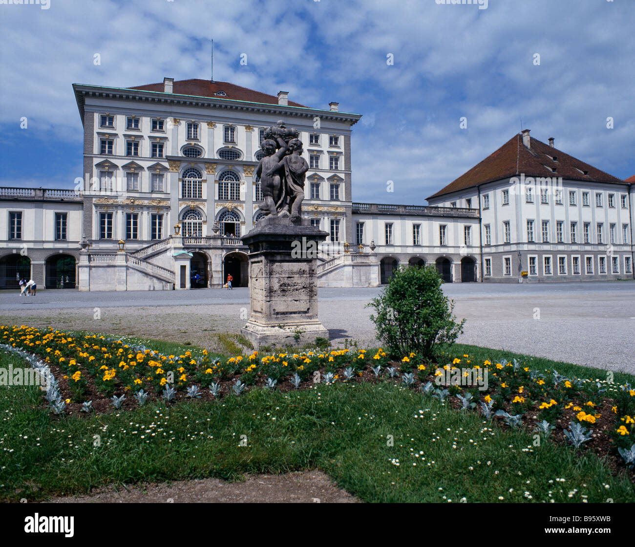 GERMANY Bavaria Munich Nymphenberg Palace. Stone statue on plinth with flower bed in foreground Stock Photo
