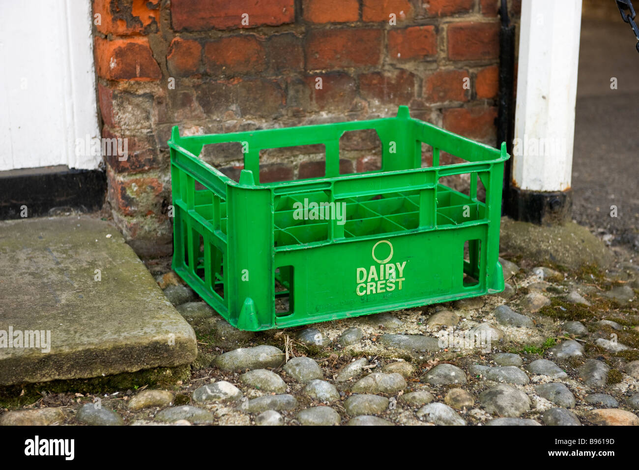 A green dairy plastic milk crate left by a doorstep Stock Photo - Alamy