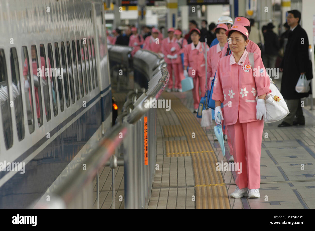 JAPAN Honshu Tokyo A cleaning crew of middle aged women in uniform wait to board a bullet train shinkansen  to clean it. Stock Photo
