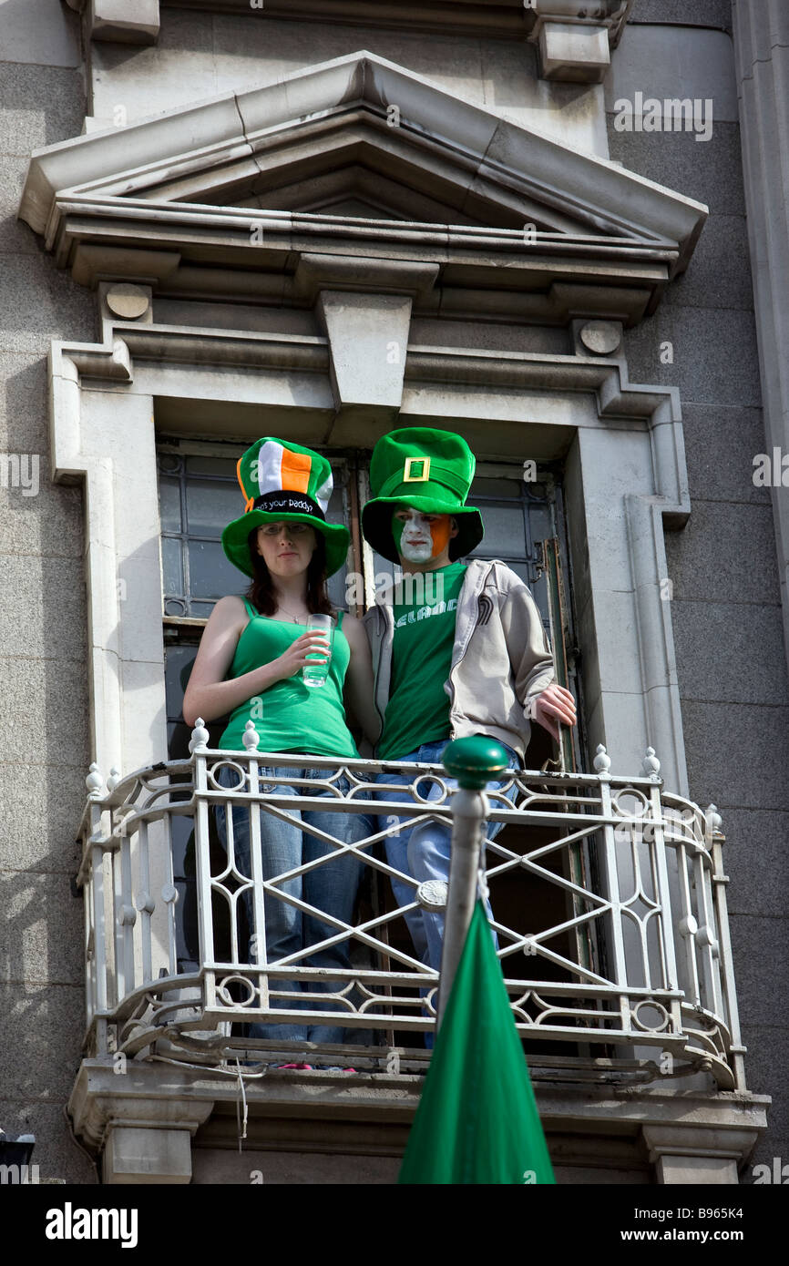 Couple watch the Dublin St Patrick s Day parade from balcony on O Connell Street Dublin Stock Photo