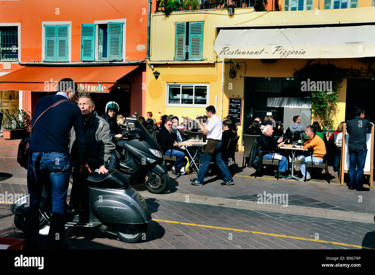 Nice France, French Pizzeria Restaurant Front Sidewalk Crowded terrace on 'Cours Saleya' motorcycles scooters Stock Photo