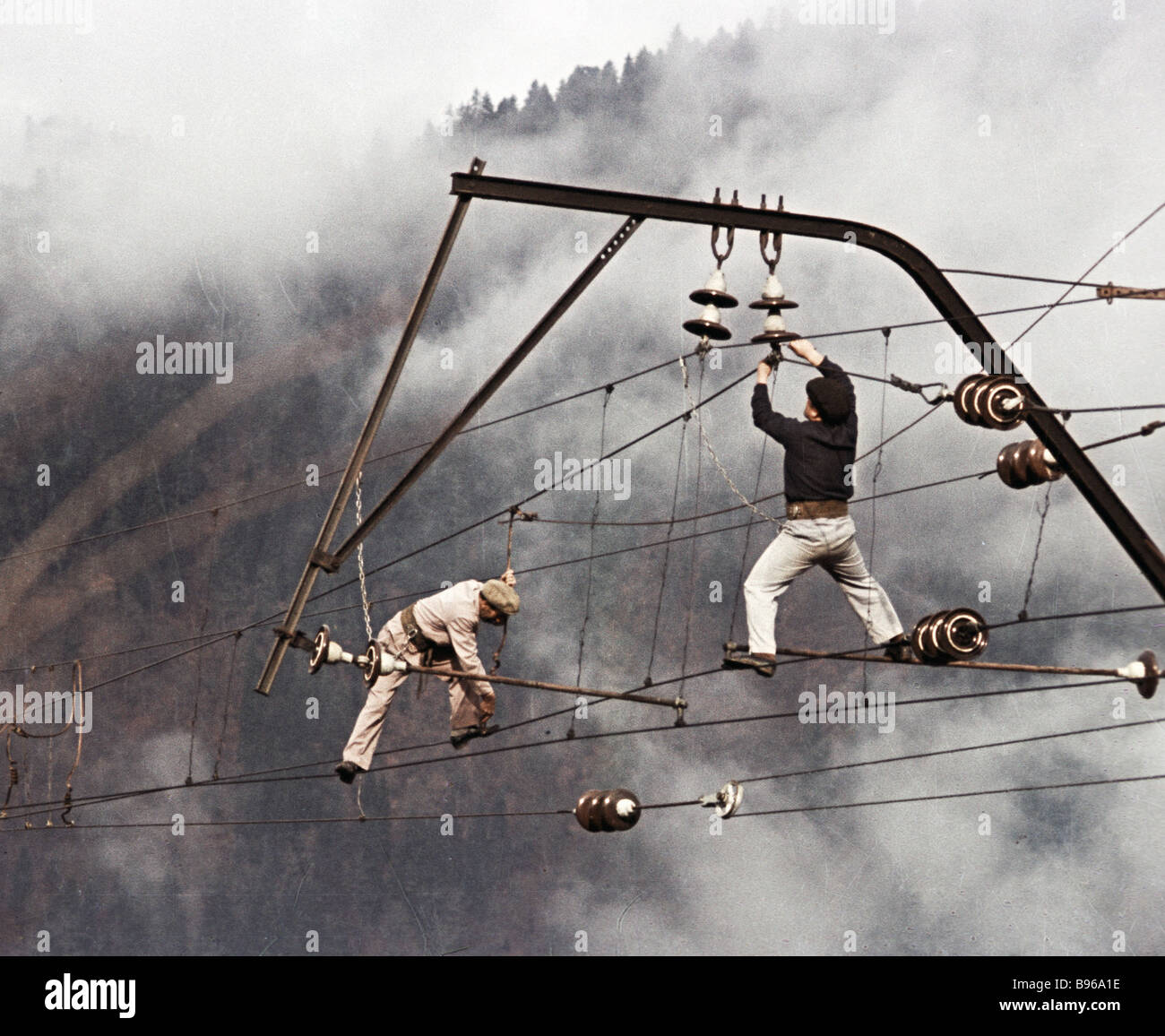 Electrical riggers standing on lines checking the catenary system on ...