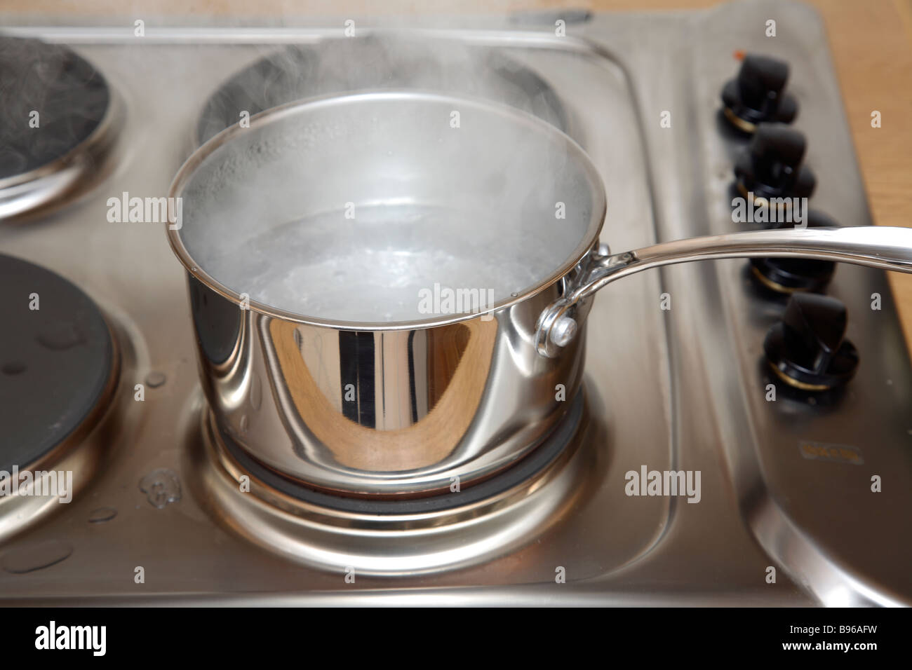 A stainless steel sausepan with steam. Stock Photo