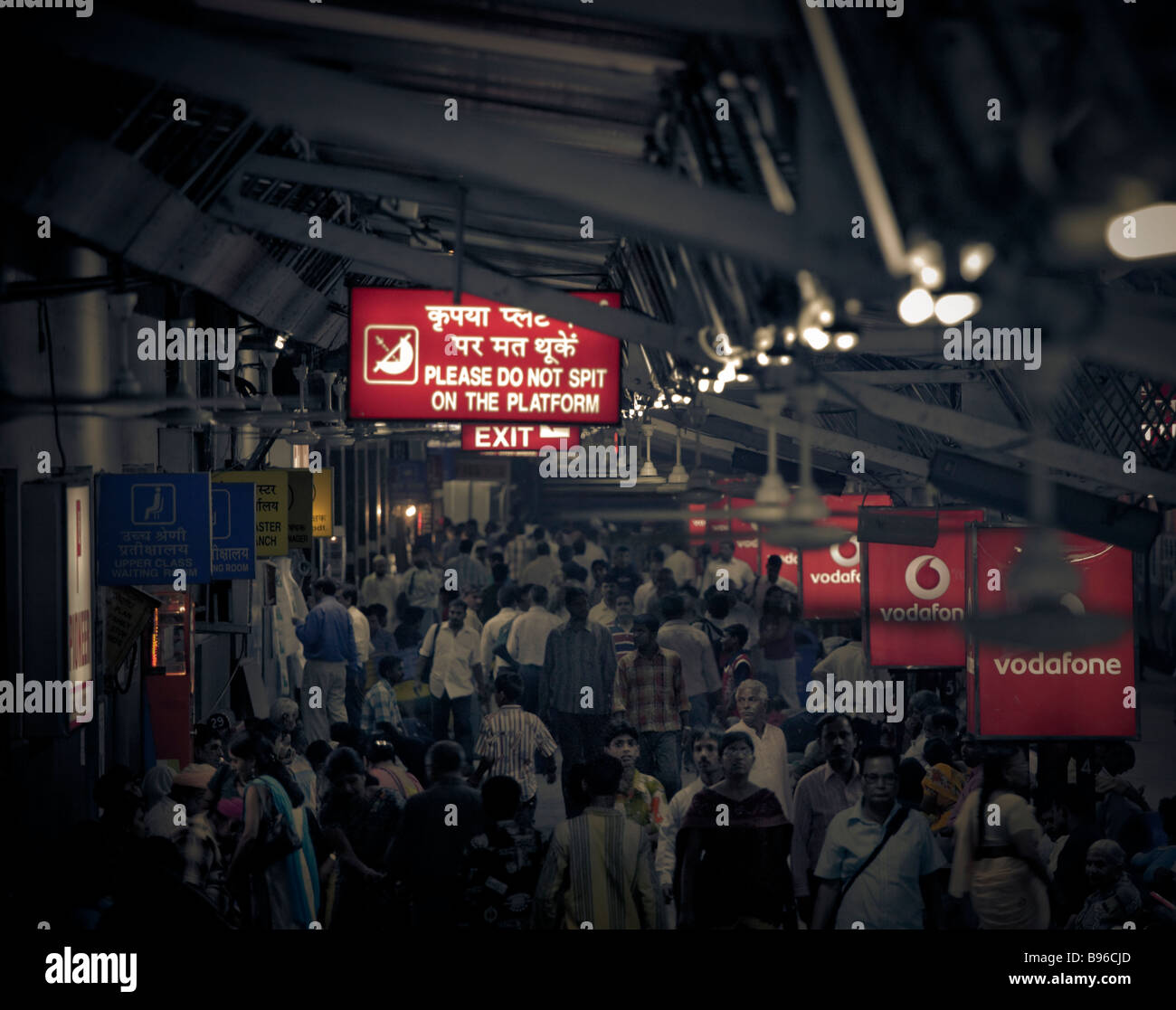 Platform at Delhi train station with passengers waiting and please do not spit red sign Stock Photo